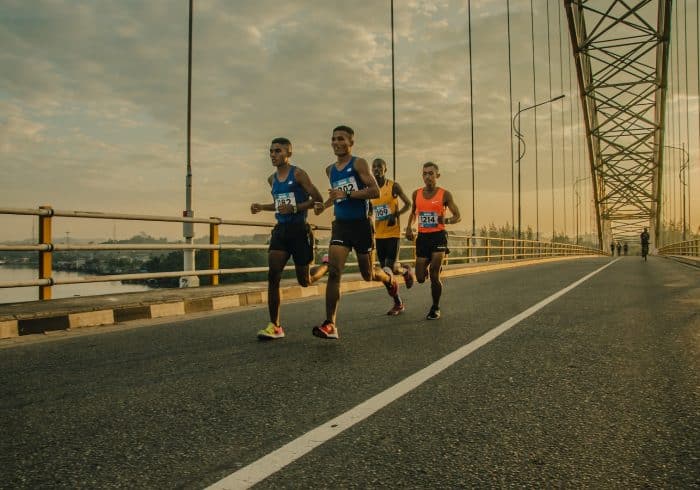 four men running on asphalt floor