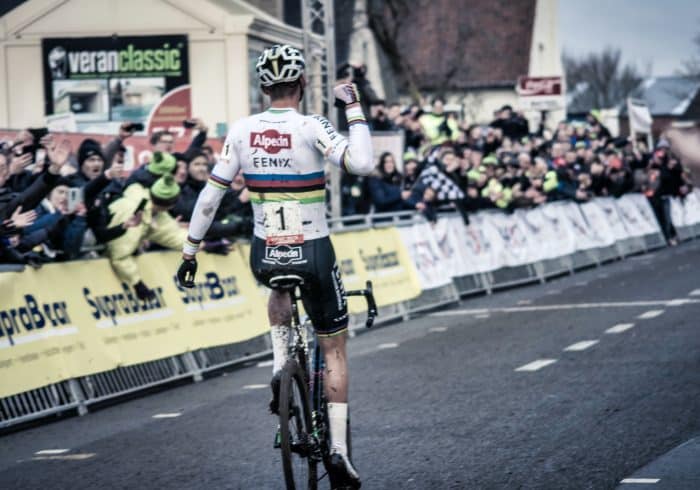 a man riding a bike down a street next to a crowd